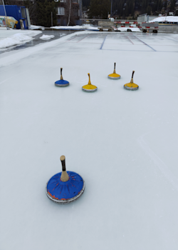 Bild der offenen Kunsteisbahn mit einigen Eisstocköcken verteilt auf dem Eis.