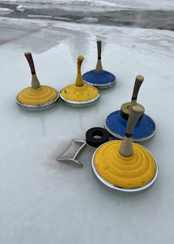 Bild der offenen Kunsteisbahn mit einigen Eisstocköcken verteilt auf dem Eis.