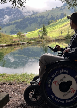 Stephan Gmür sitzt im JST Mountain Drive-Rollstuhl am Blauseeli und geniesst die Aussicht.